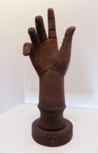 A wooden hand sculpture on top of a table.