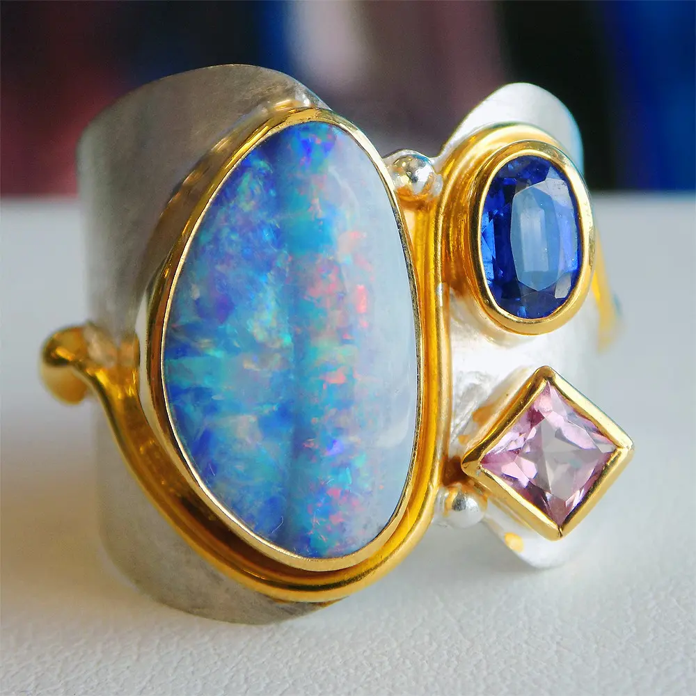 A ring with a blue stone and a pink diamond.