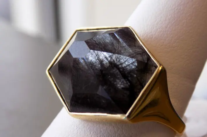 A gold ring with a black stone on top of it.