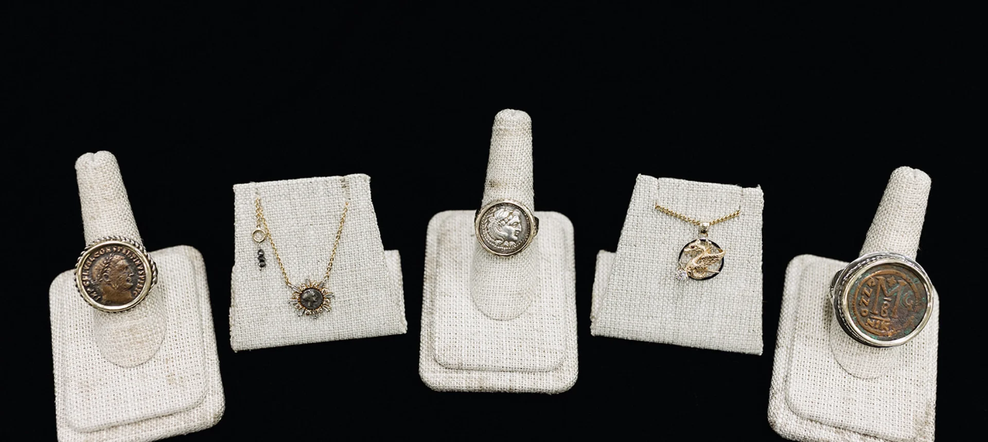Assorted coin rings and necklaces displayed