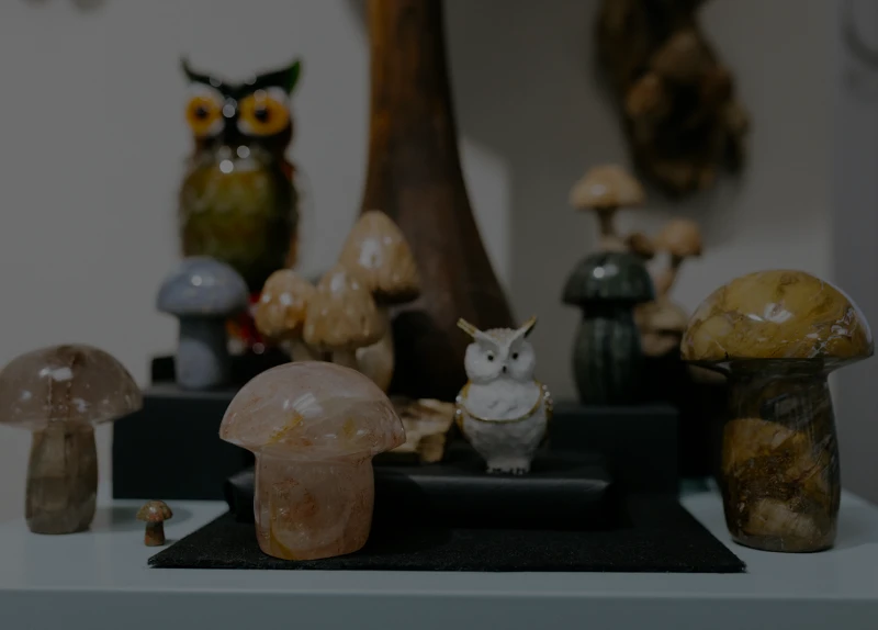 Owl and mushroom sculptures on shelf